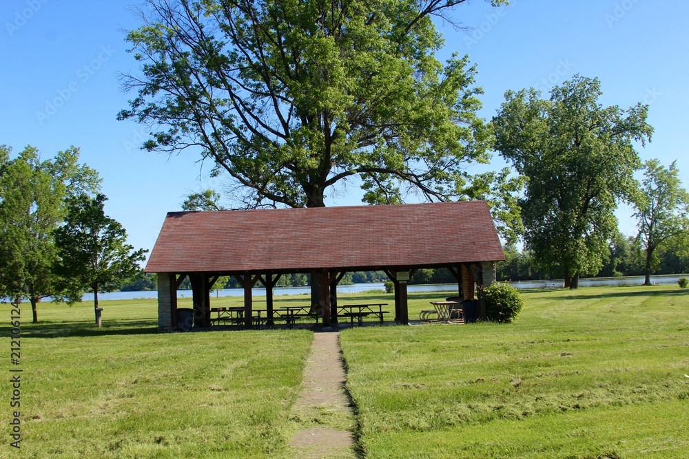 A empty picnic shelter with a view of the lake in at the park A empty picnic shelter with a view of the lake in at the park