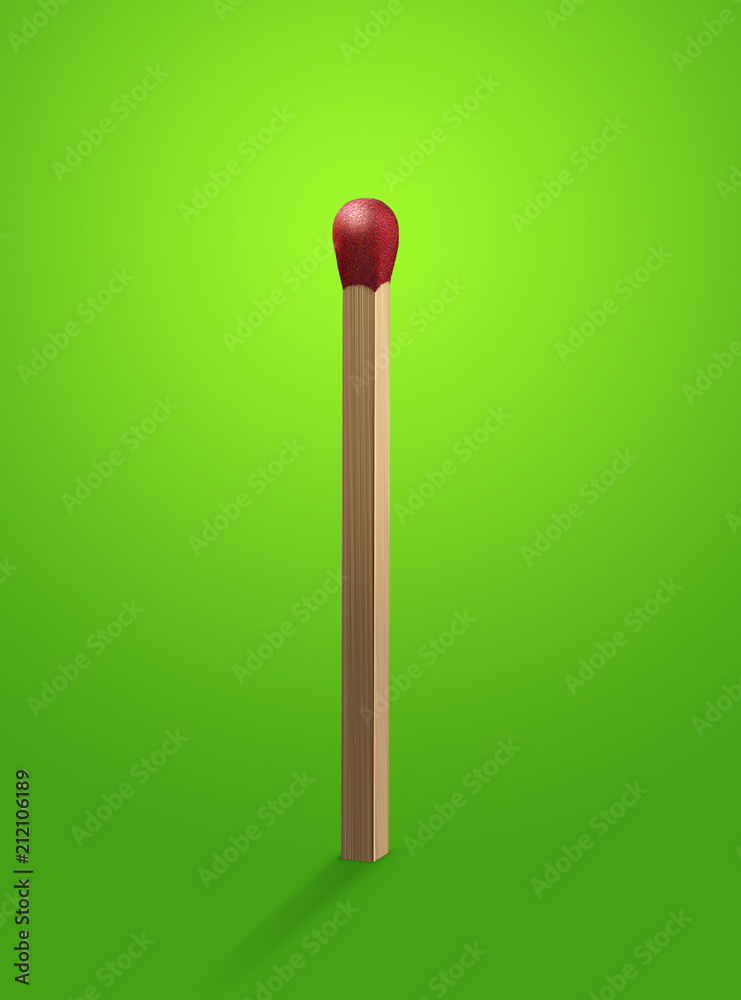Red head match stick standing upright on green background Red head match stick standing upright on green background