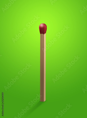 Red head match stick standing upright on green background