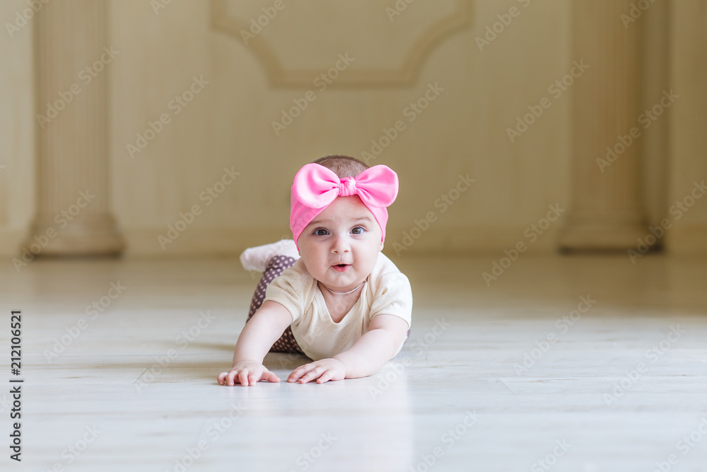 a little girl whose half a year, 6 months old, in cute body and skirt, with bright bow on a head. Sweet smiling Baby girl in studio a little girl whose half a year, 6 months old, in cute body and skirt, with bright bow on a head. Sweet smiling Baby girl in studio