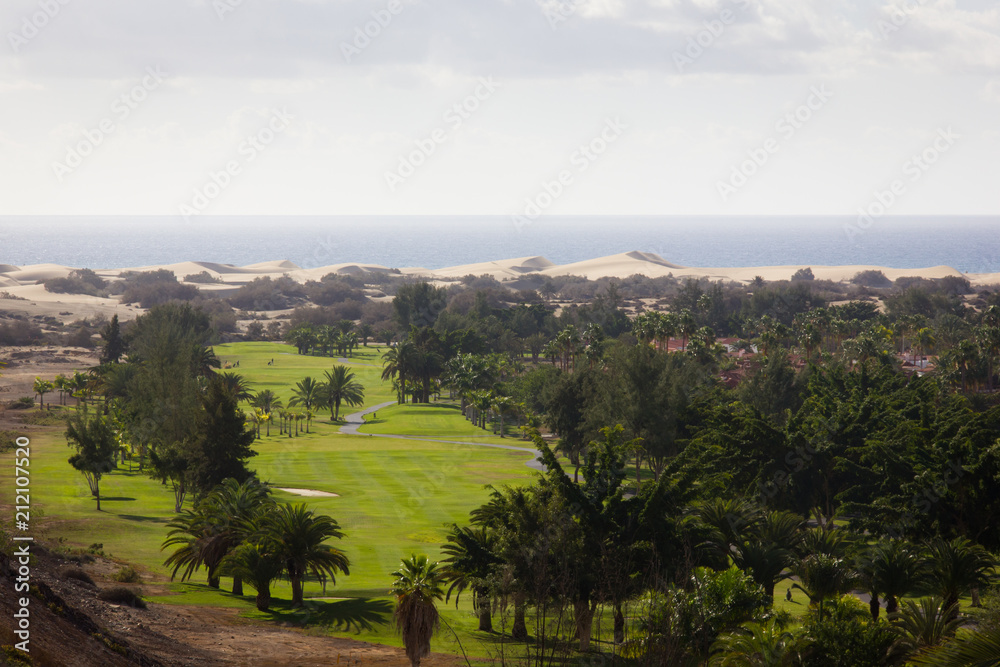 Great view of Maspalomas golf course with sand dunes and ocean on the background on sunny day in Gran Canaria island, Spain. Summer vacation, relax destination concept