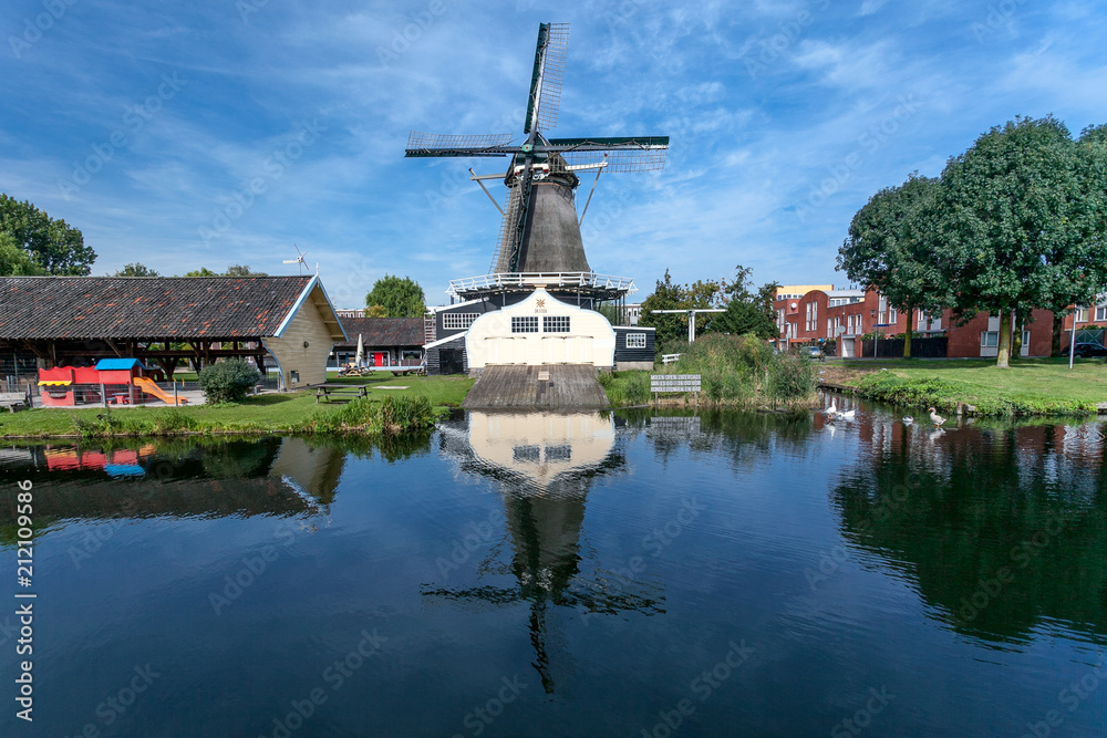 Windmill and mirrored in the water in front