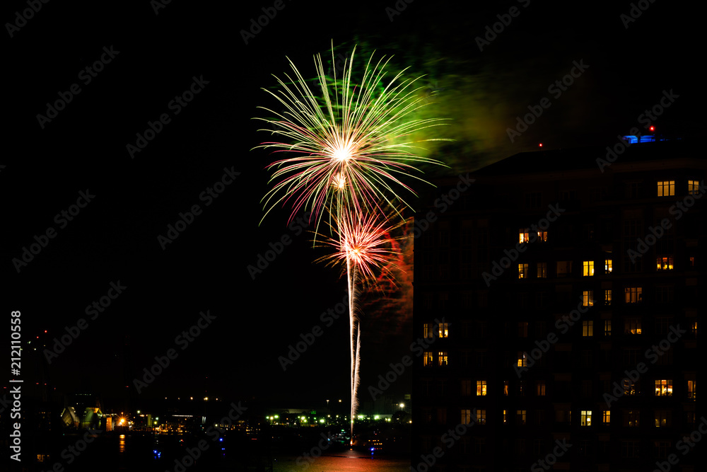 A Fourth of July fireworks display explodes over the waterfront in the city center of Norfolk Virginia, in the context of buildings, apartments, and dwellings A Fourth of July fireworks display explodes over the waterfront in the city center of Norfolk Virginia, in the context of buildings, apartments, and dwellings