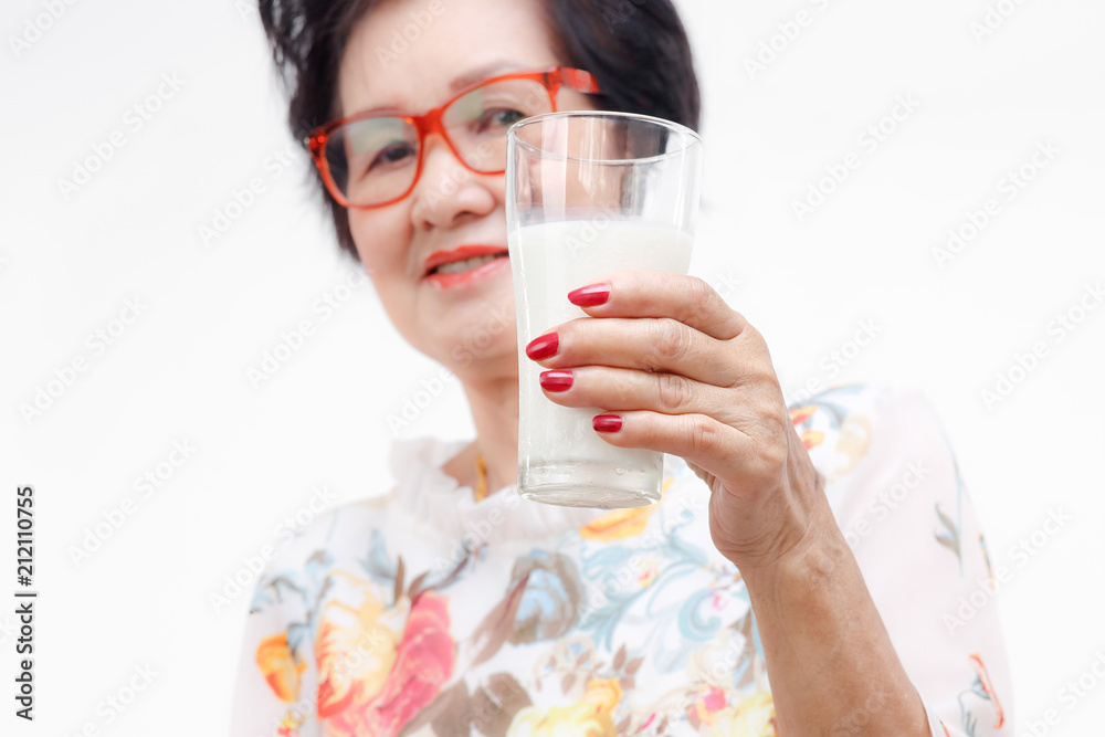 Senior woman holding a glass of milk , isolated on white background. Senior woman holding a glass of milk , isolated on white background.