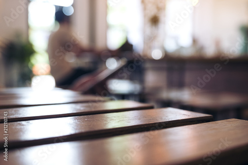 Wooden table and chair in cafe with blur bokeh abstract vintage background