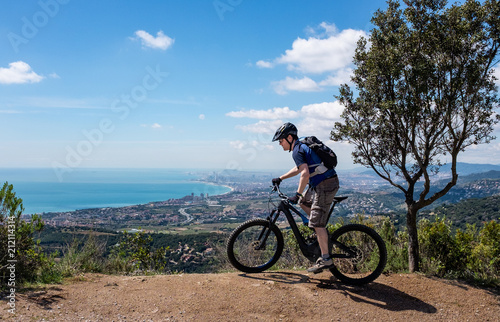Mountain top view of cyclist on electric bike near Barcelona city Spain
