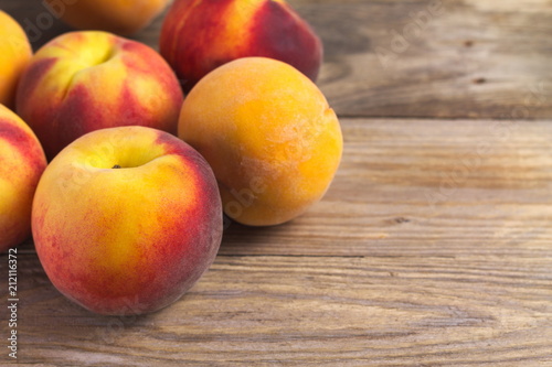 A group of ripe peaches on wooden surface