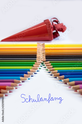 Anordnung vieler Buntstifte und einer Zuckertüte im Hoch und Querformat mit Schriftzug Schulanfang