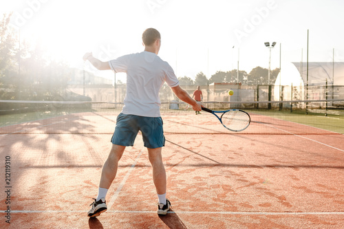  Man playing tennis in the morning in sunlight © diignat
