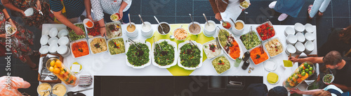 Großes vegetarisches Catering Salat  Buffet mit gesundem Essen, Salten und Obs wo sich Menschen bedienen  photo