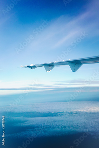Airplane wings in the sky and clouds, Classic image through aircraft window onto jet engine