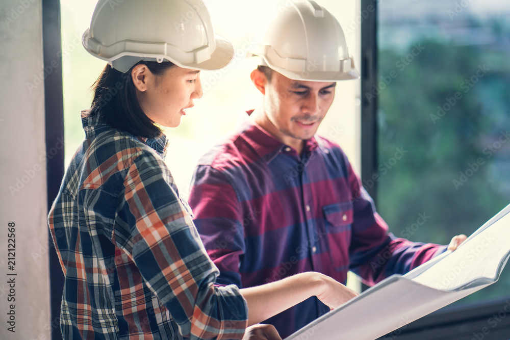 Architect & Engineer working drawing document about project planning and progress of work schedule on the home building construction site Architect & Engineer working drawing document about project planning and progress of work schedule on the home building construction site