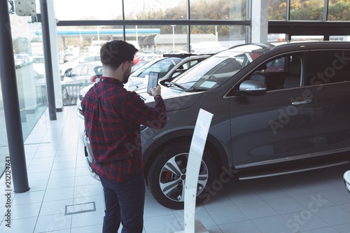 Salesman taking picture of car with mobile phone photo