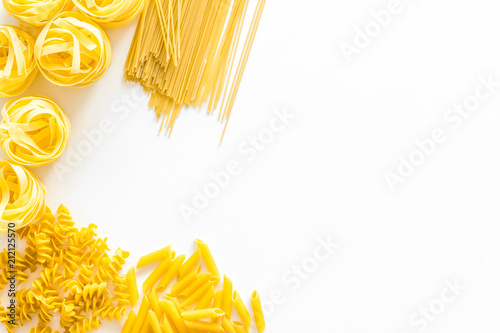 Set of pasta. Raw spaghetti, fusilli, penne, fettuccine on white background top view copy space