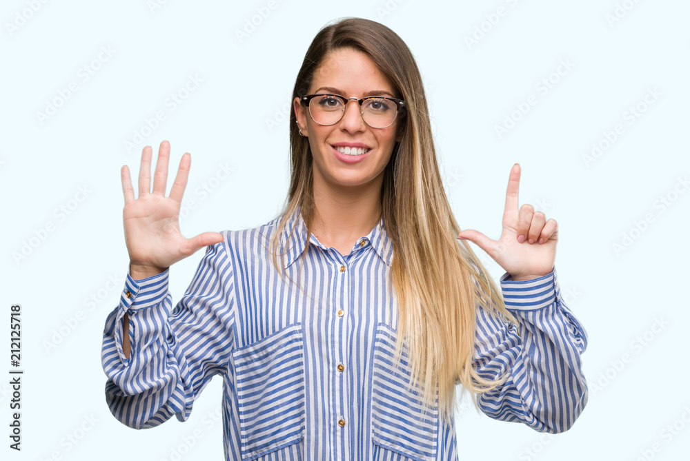 Beautiful young woman wearing elegant shirt and glasses showing and pointing up with fingers number seven while smiling confident and happy. Beautiful young woman wearing elegant shirt and glasses showing and pointing up with fingers number seven while smiling confident and happy.