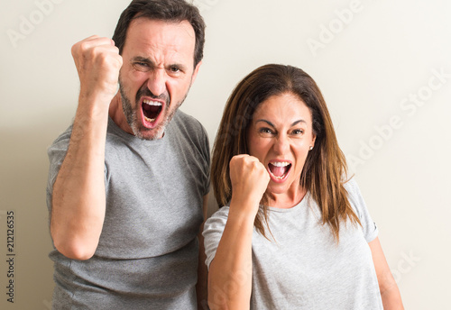 Middle age couple, woman and man annoyed and frustrated shouting with anger, crazy and yelling with raised hand, anger concept