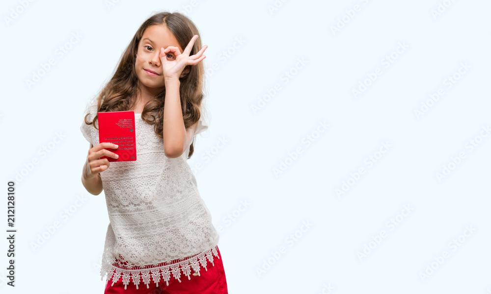 Brunette hispanic girl holding passport of Switzerland with happy face smiling doing ok sign with hand on eye looking through fingers Brunette hispanic girl holding passport of Switzerland with happy face smiling doing ok sign with hand on eye looking through fingers