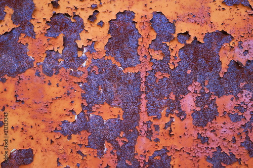 An old painted sheet of iron covered with rust. Abstract background.