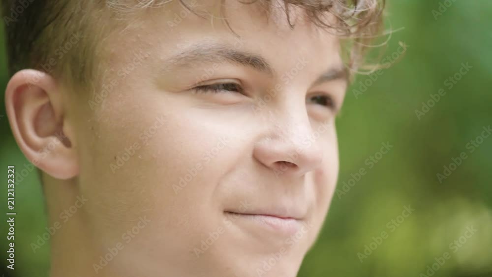 Close up emotional portrait of caucasian smiling teen boy. Handsome guy. Funny cute teenager in summer park at day. Child looking away. Close up emotional portrait of caucasian smiling teen boy. Handsome guy. Funny cute teenager in summer park at day. Child looking away.