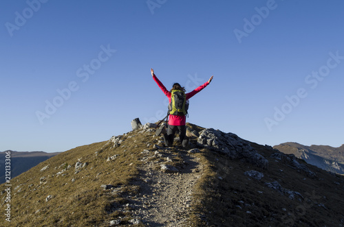 Happy woman jumping on the top of a mountain