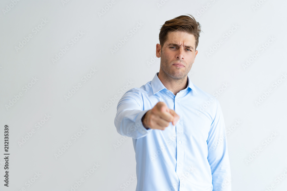 Portrait of frowning businessman pointing at camera with finger. Serious Caucasian executive making choice. Recruitment concept Portrait of frowning businessman pointing at camera with finger. Serious Caucasian executive making choice. Recruitment concept