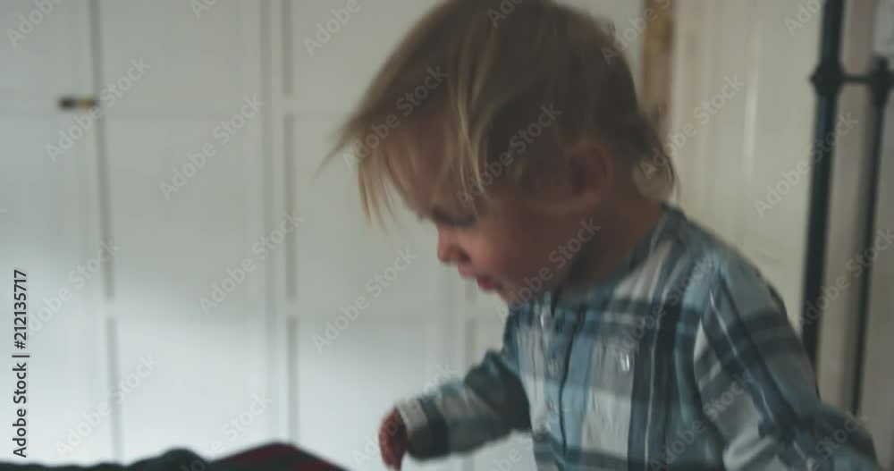 Little toddler boy throwing himself on a bed Little toddler boy throwing himself on a bed