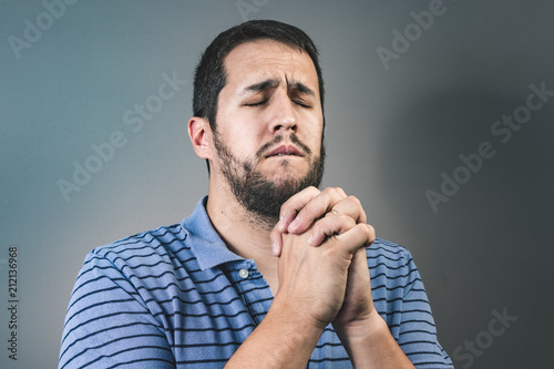 Portrait of man showing clasped hands, asking for help or excuse. Please, forgive me the concept photo