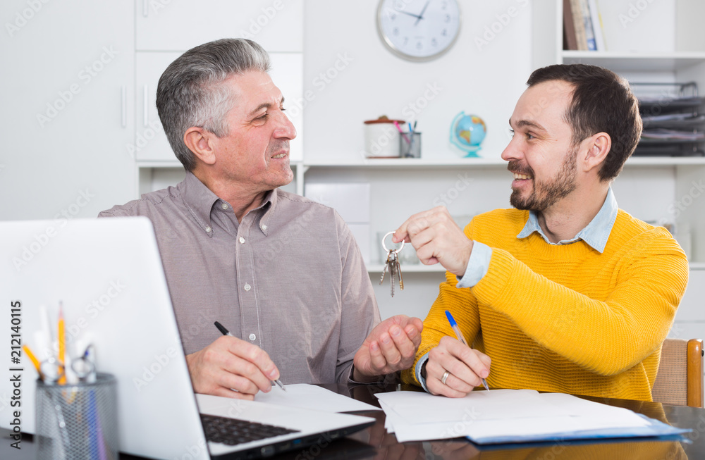 Mature man and agent sign rental agreement