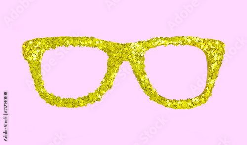 Luxury golden glasses with stars from confetti on pink background.