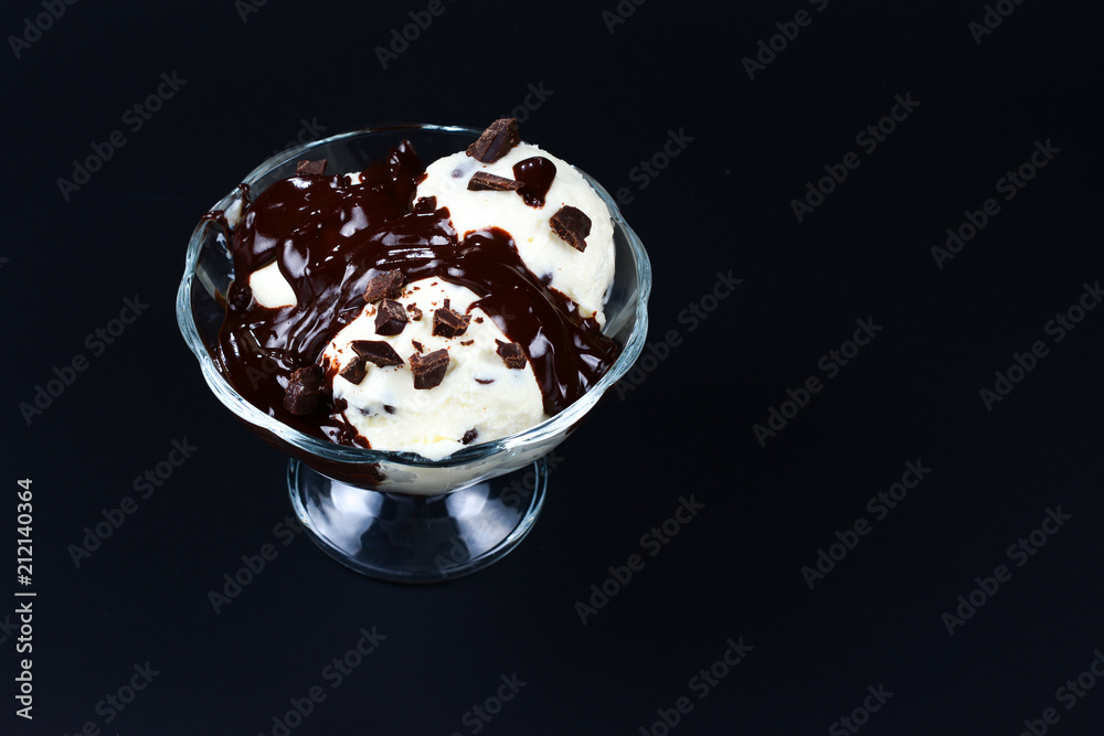 Vanilla ice cream in a white bowl with chocolate on a black background. Vanilla ice cream in a white bowl with chocolate on a black background.