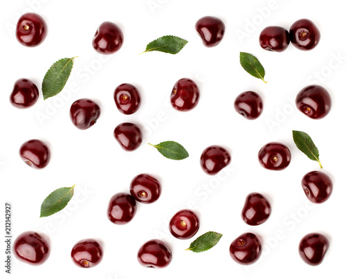 Red cherries and leaves scattered on a white, top view. Fruit background.