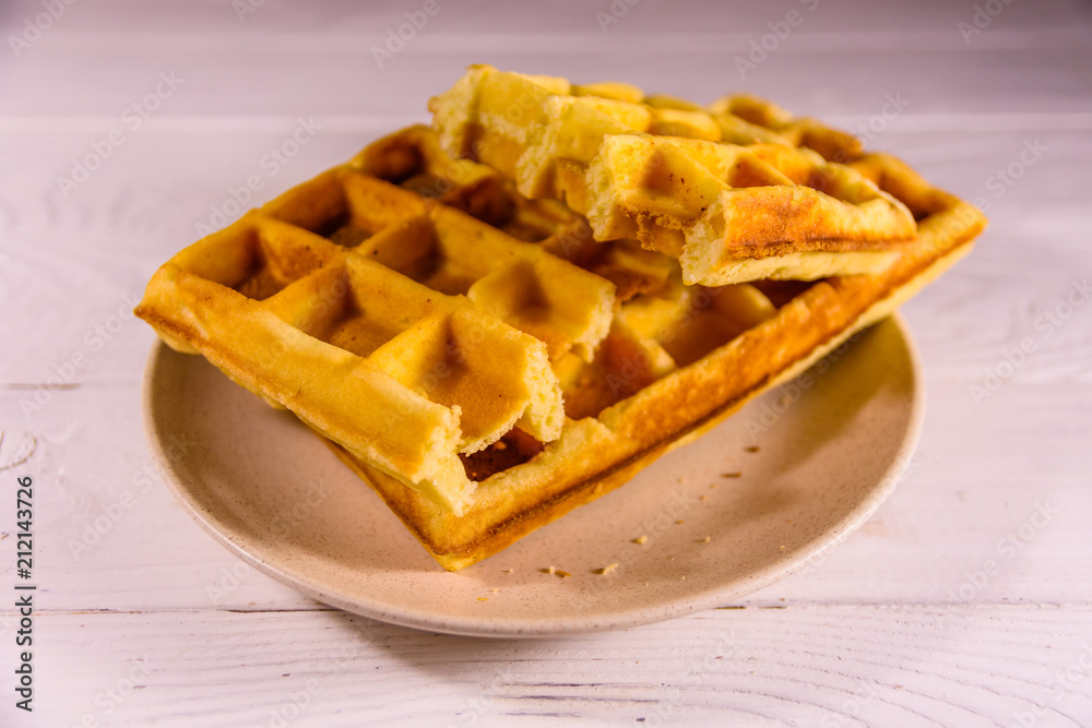 Ceramic plate with belgian waffles on wooden table Ceramic plate with belgian waffles on wooden table