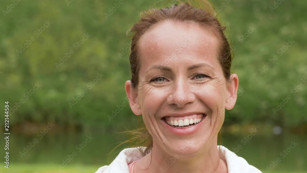 people concept - portrait of happy smiling middle-aged woman in park