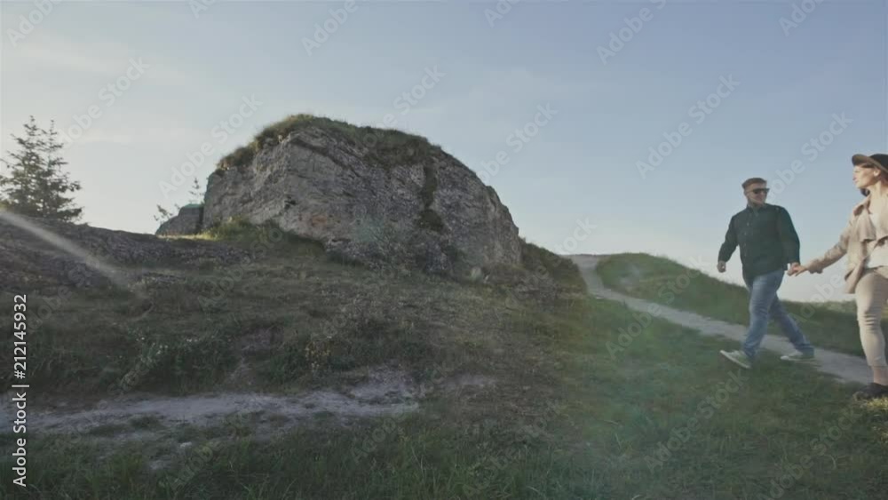 Young couple holding hands hiking in the mountains