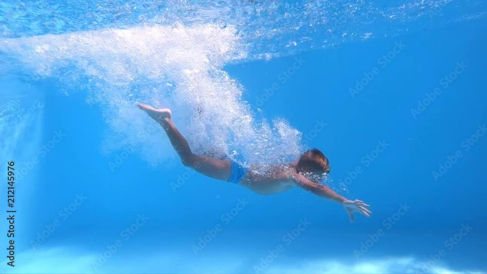 Jump into the water. Boy jumping into the water. Underwater shot. Slow motion.