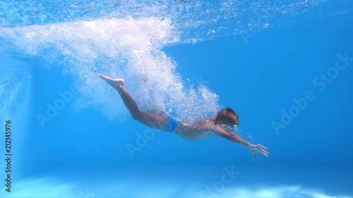 Jump into the water. Boy jumping into the water. Underwater shot. Slow motion.