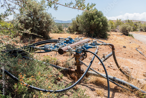 Unique field irrigation pipeline system infrastructure used in agriculture .  Watering system  with multi directional multiple water supply pipelines in Crete, Greece.  Agriculture industry concept photo