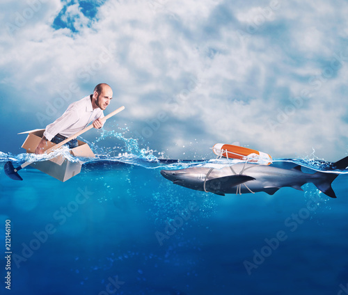 Businessman on a cardbox in the ocean looks for an help. Help with deception concept