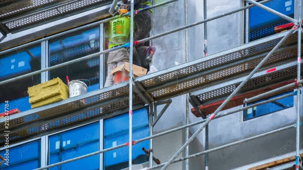 Finishing work on a facade of a new building under construction. Builders plastered the facade of the building. Time lapse 