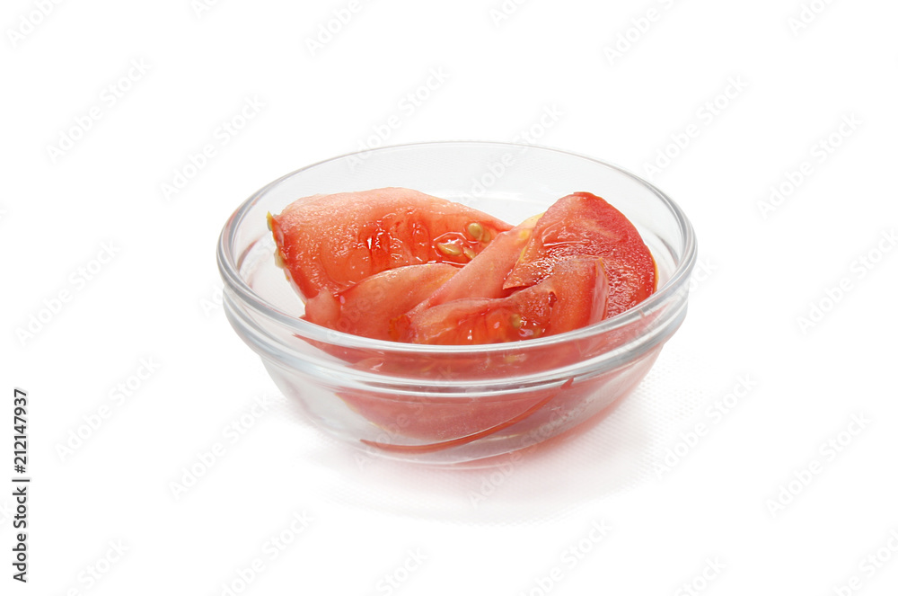 Slices of tomato in glass bowl isolated on white background. Slices of tomato in glass bowl isolated on white background.