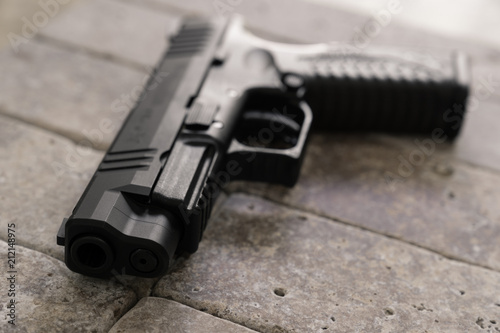 Handgun closeup on stone tiles