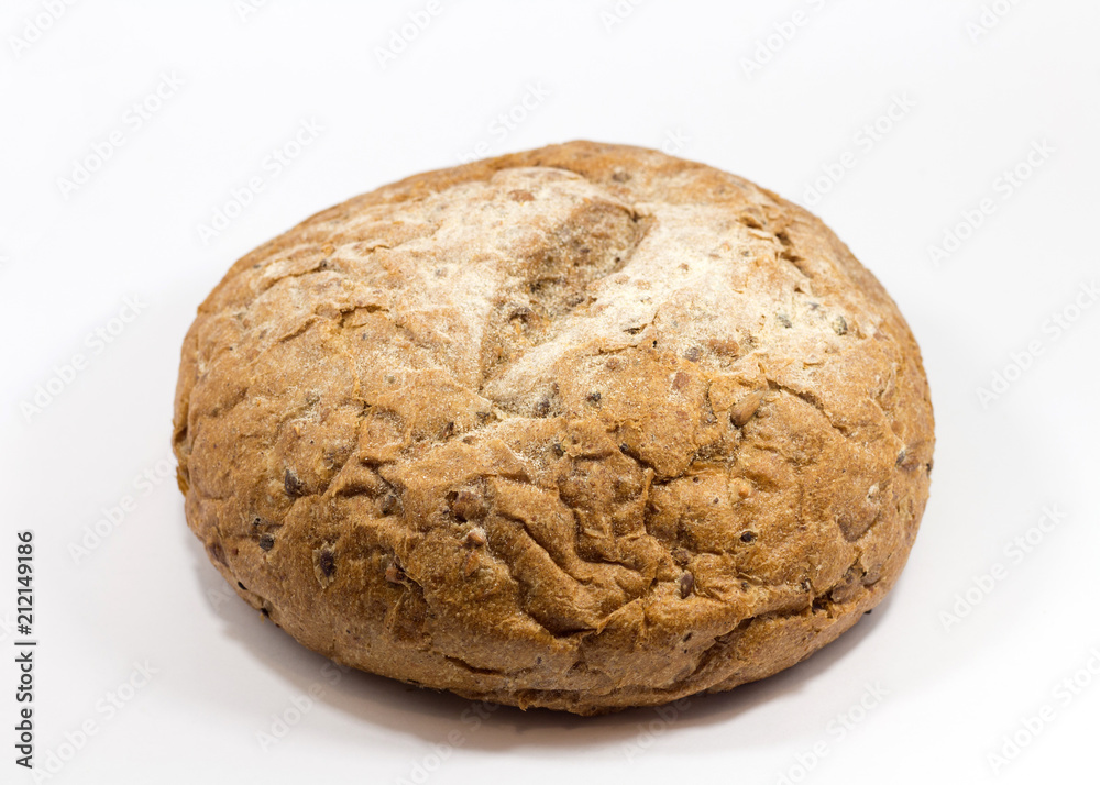 One round grain bread isolated on a white background.Whole fresh wheat and rye small bread with a lot of seeds: sunflower, pumpkin, sesame. One round grain bread isolated on a white background.Whole fresh wheat and rye small bread with a lot of seeds: sunflower, pumpkin, sesame.