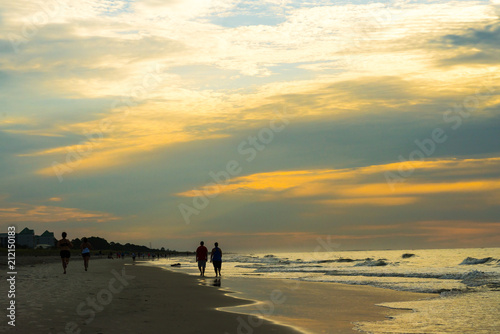 silhouette of people walking on beach at sunrise on Hilton Head Island SC.