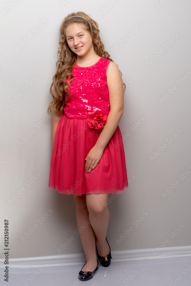 A little girl with long silky hair near the wall. A little girl with long silky hair near the wall.