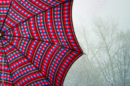 Red umbrella with bright ornament on winter background