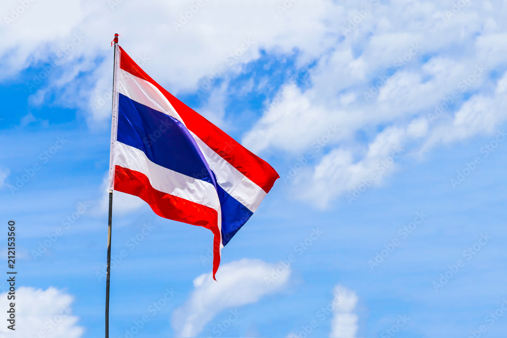 flag of Thailand on flagpole red white horizontal stripes develops against a background of light sky and white cloud