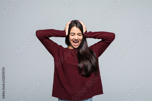 Full length of Happy screaming woman in t-shirt holding her head and looking at the camera over grey background © F8  \ Suport Ukraine