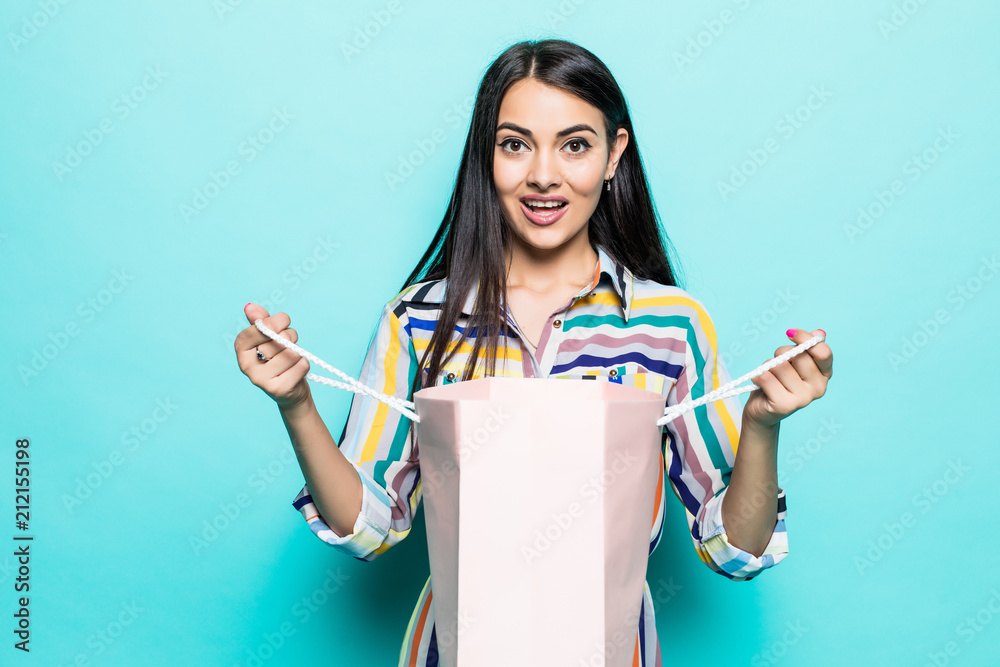 Close up Portrait young beautiful attractive redhair girl smiling open shocked shopping bag on Blue Pastel Background. Close up Portrait young beautiful attractive redhair girl smiling open shocked shopping bag on Blue Pastel Background.