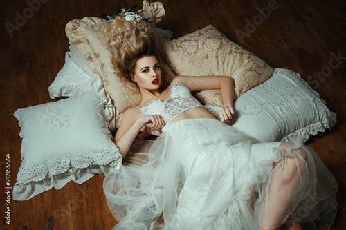 Beautiful blondie girl is sexually posing with  a Middle Ages historical hairstyle