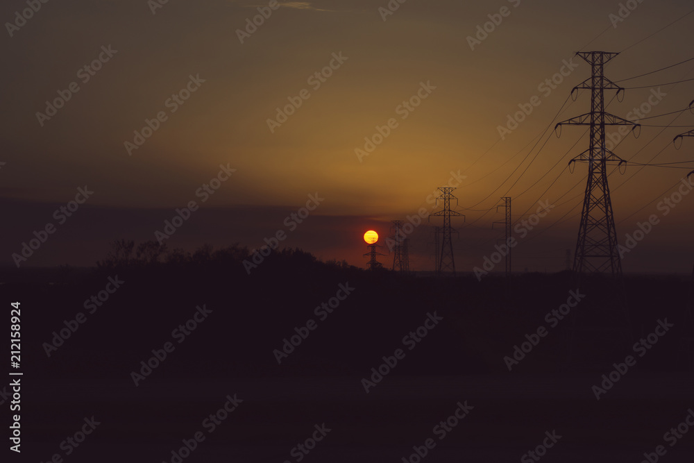 high voltage electric poles with sunset and evening sky background, filtered tones